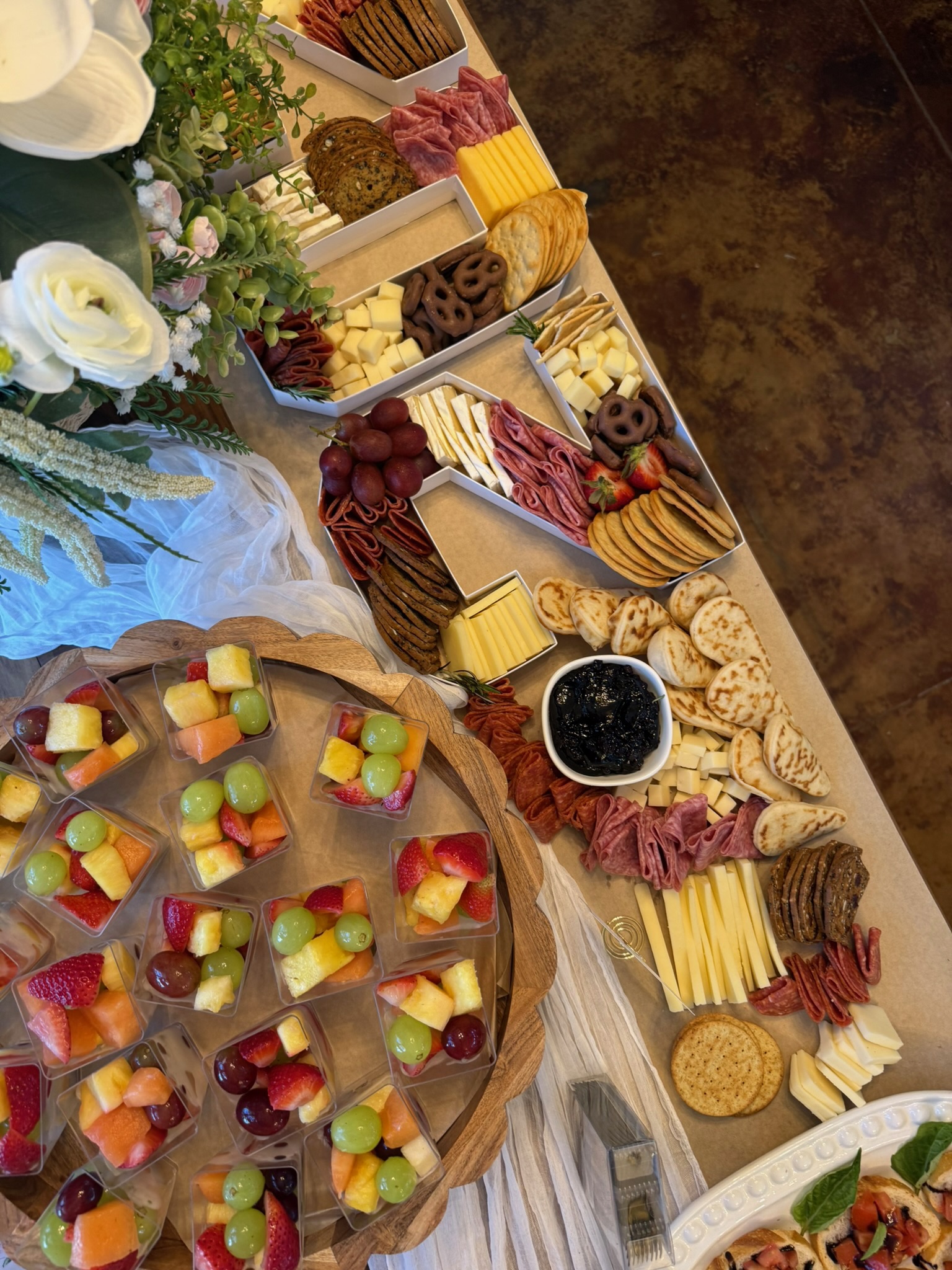Aerial view of full catering spread with fruit cups, individual boxes, and grazing table