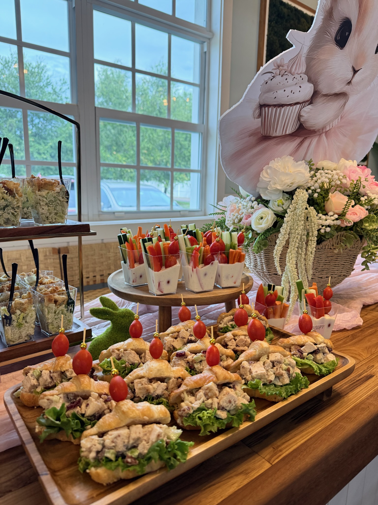 Spring themed event with chicken salad croissants, veggie cups, and floral decor